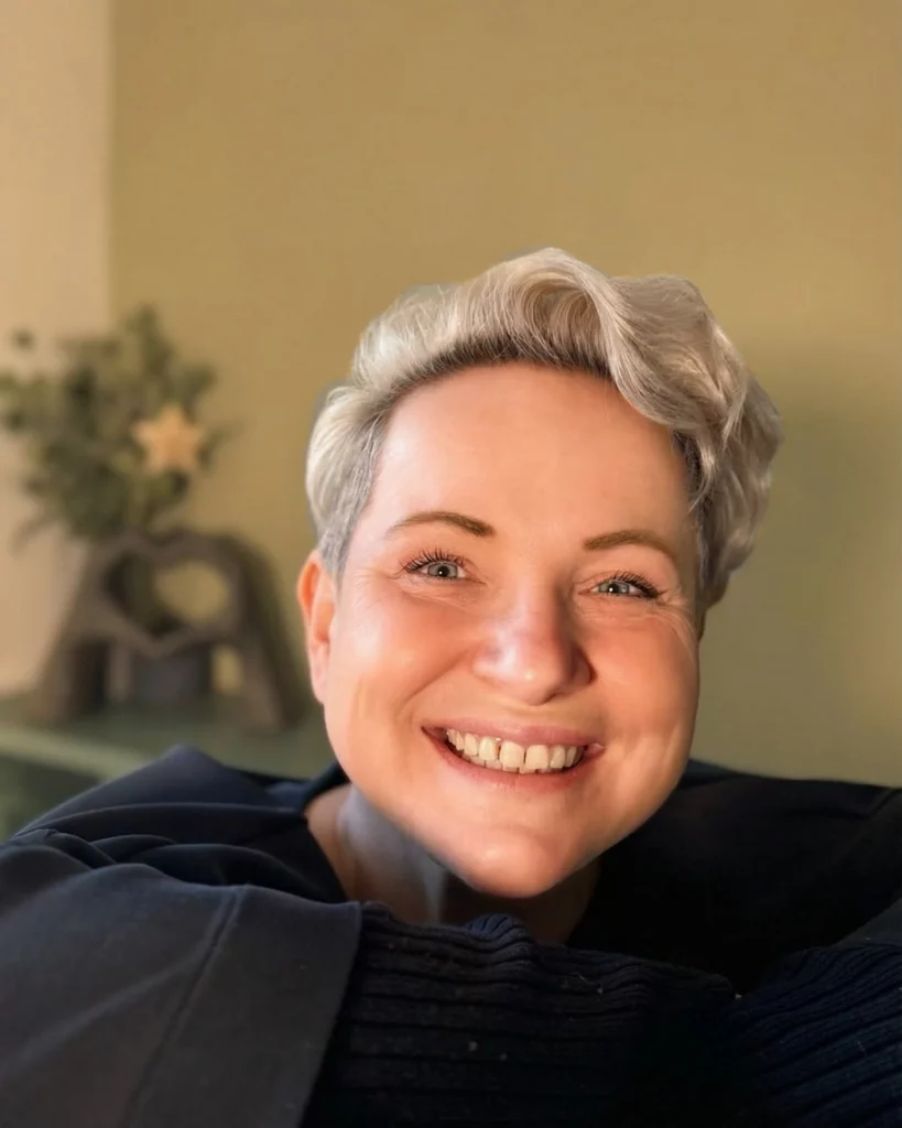 Doreeb, Coach für berufliche Neuorientierung, lächelnd im warmen Licht vor ruhigem, grünen Hintergrund